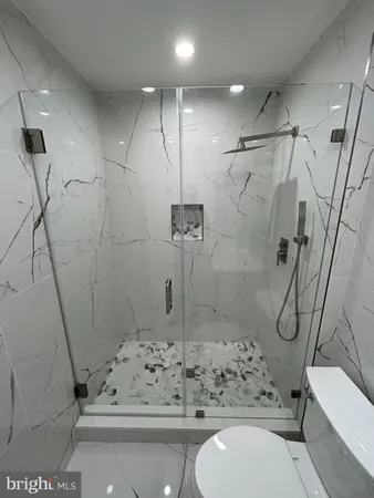 a bathroom with a glass door shower and toilet