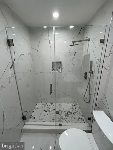 a bathroom with a glass door shower and toilet