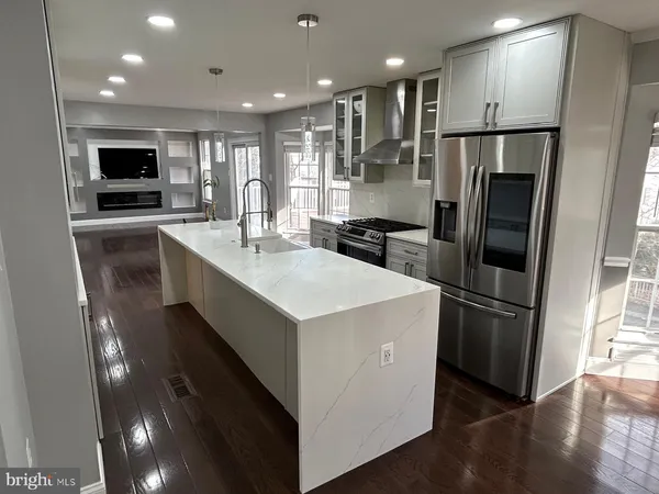 a kitchen with stainless steel appliances granite countertop a refrigerator a sink a stove and a microwave