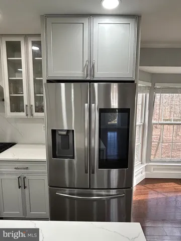 a view of kitchen with stainless steel appliances wooden floor and window