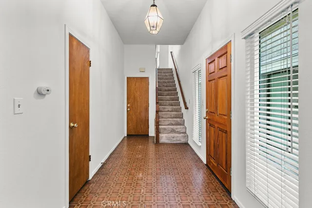 a view of a hallway with wooden floor and stairs