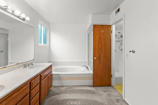 a bathroom with a tub sink and mirror