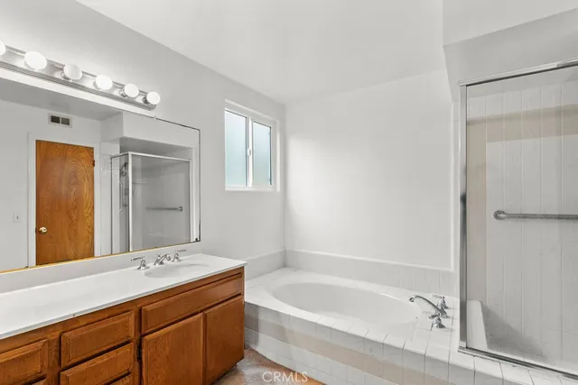 a bathroom with a tub a sink and mirror