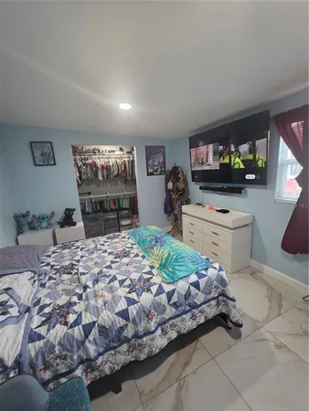 a bedroom with a bed and a flat screen tv