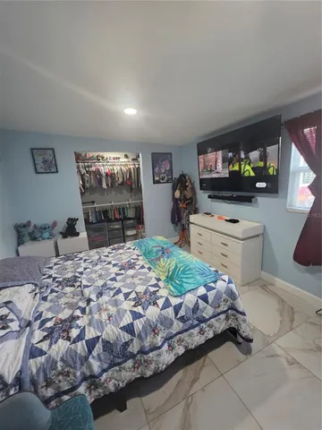 a bedroom with a bed and a flat screen tv