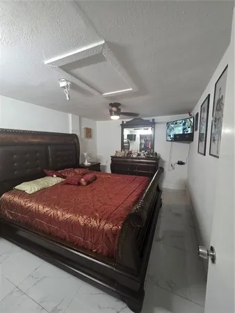 a large bed sitting in a bedroom next to a larger window