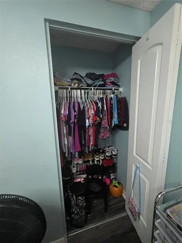 a view of walk in closet with clothes and shoes