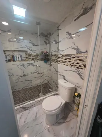 a bathroom with a toilet and a shower