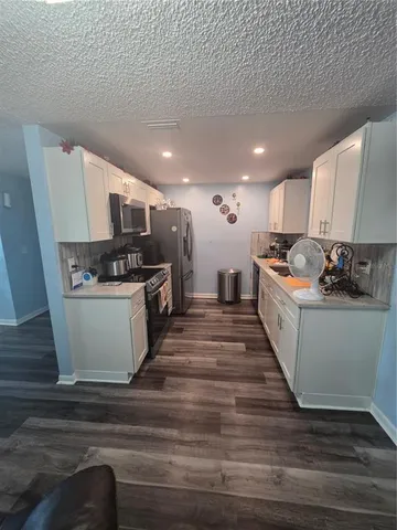a kitchen with stainless steel appliances kitchen island granite countertop a stove and a refrigerator