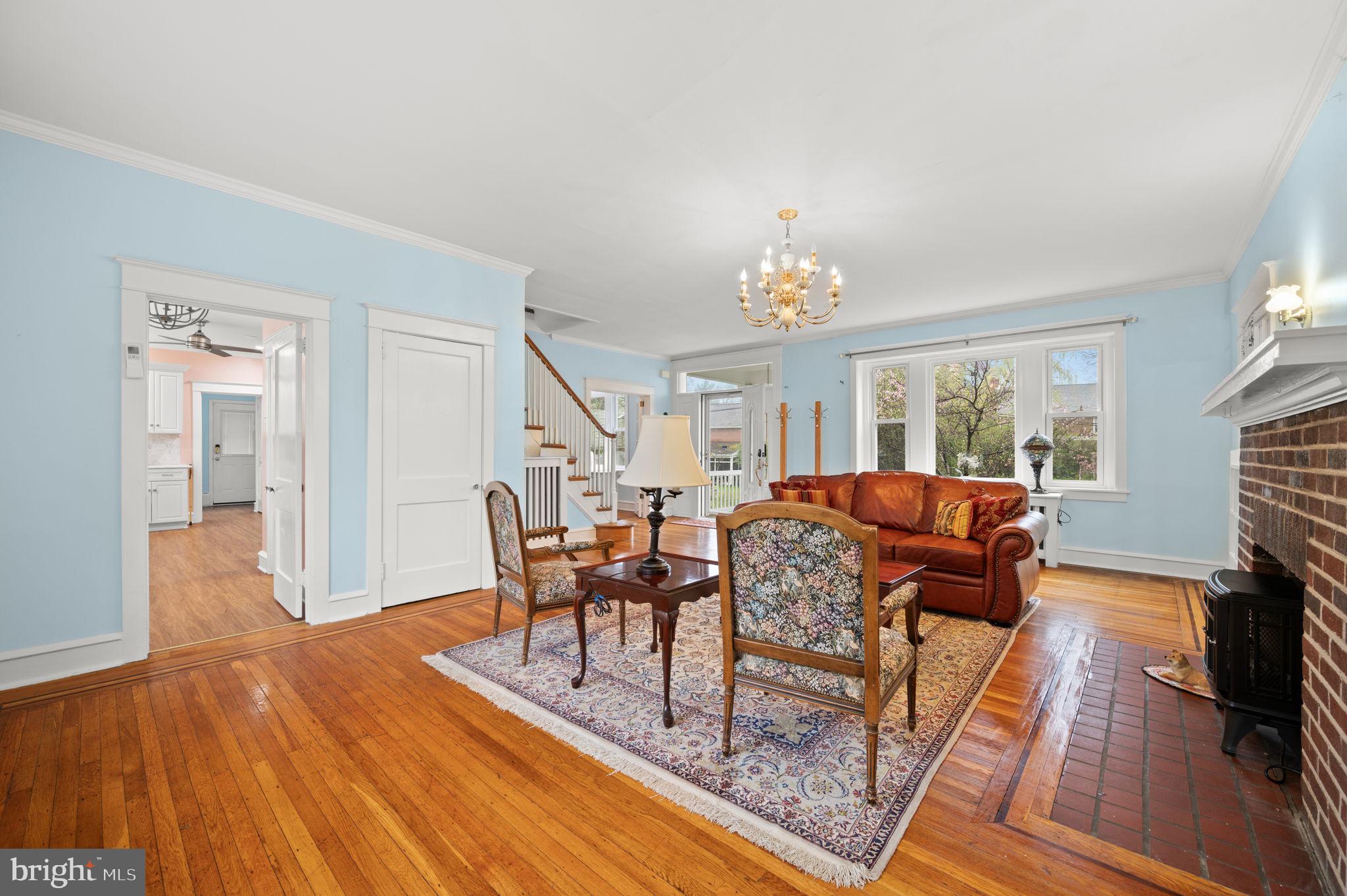 332 South Providence Road Wallingford, PA 19086 - Photo 11 of 69 a living room with furniture a fireplace and a dining table with wooden floor