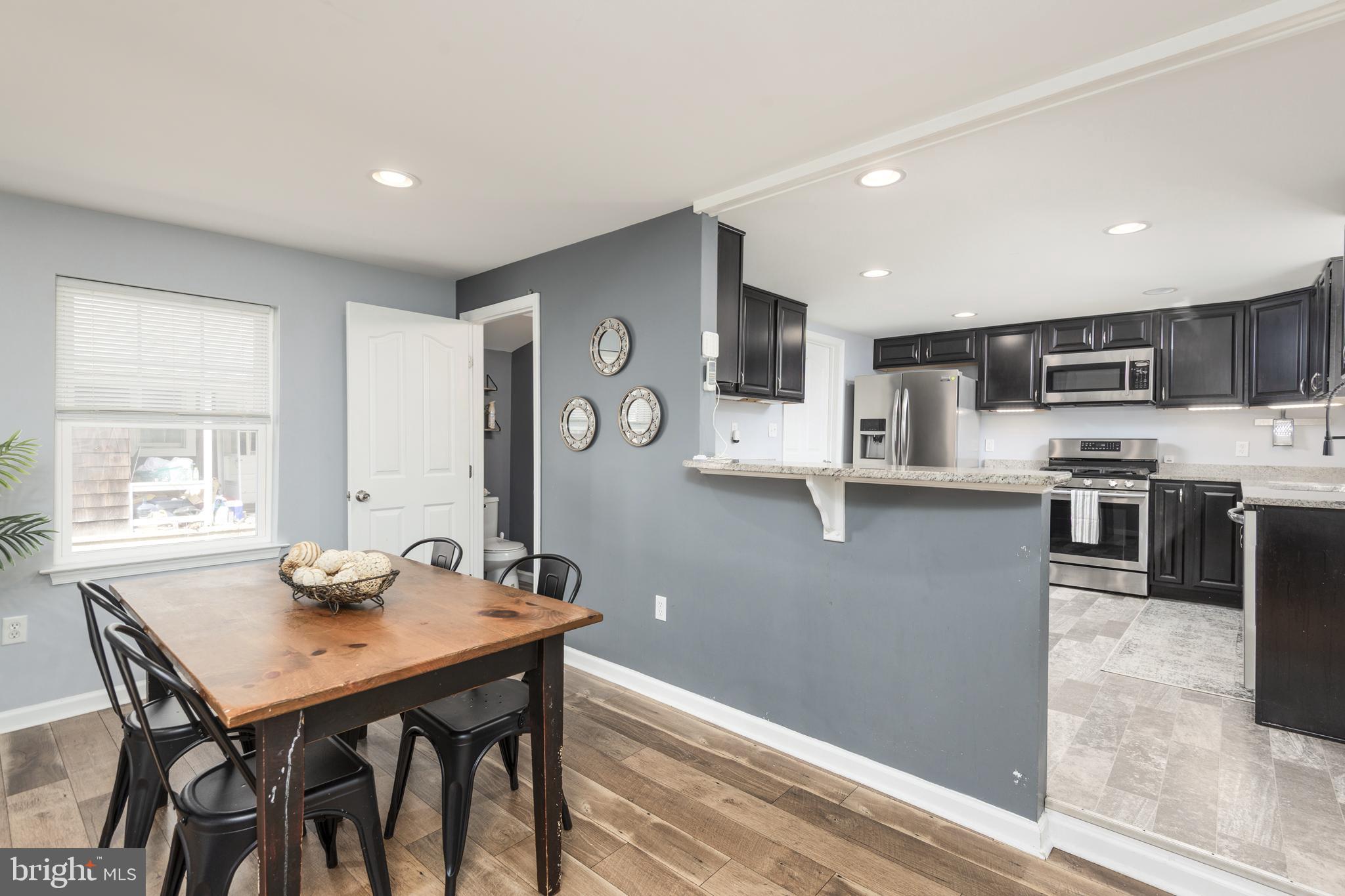 515 Franklin Street Denton, MD 21629 - Photo 6 of 21 a kitchen with stainless steel appliances granite countertop a stove top oven a sink a refrigerator with a dining table and chairs