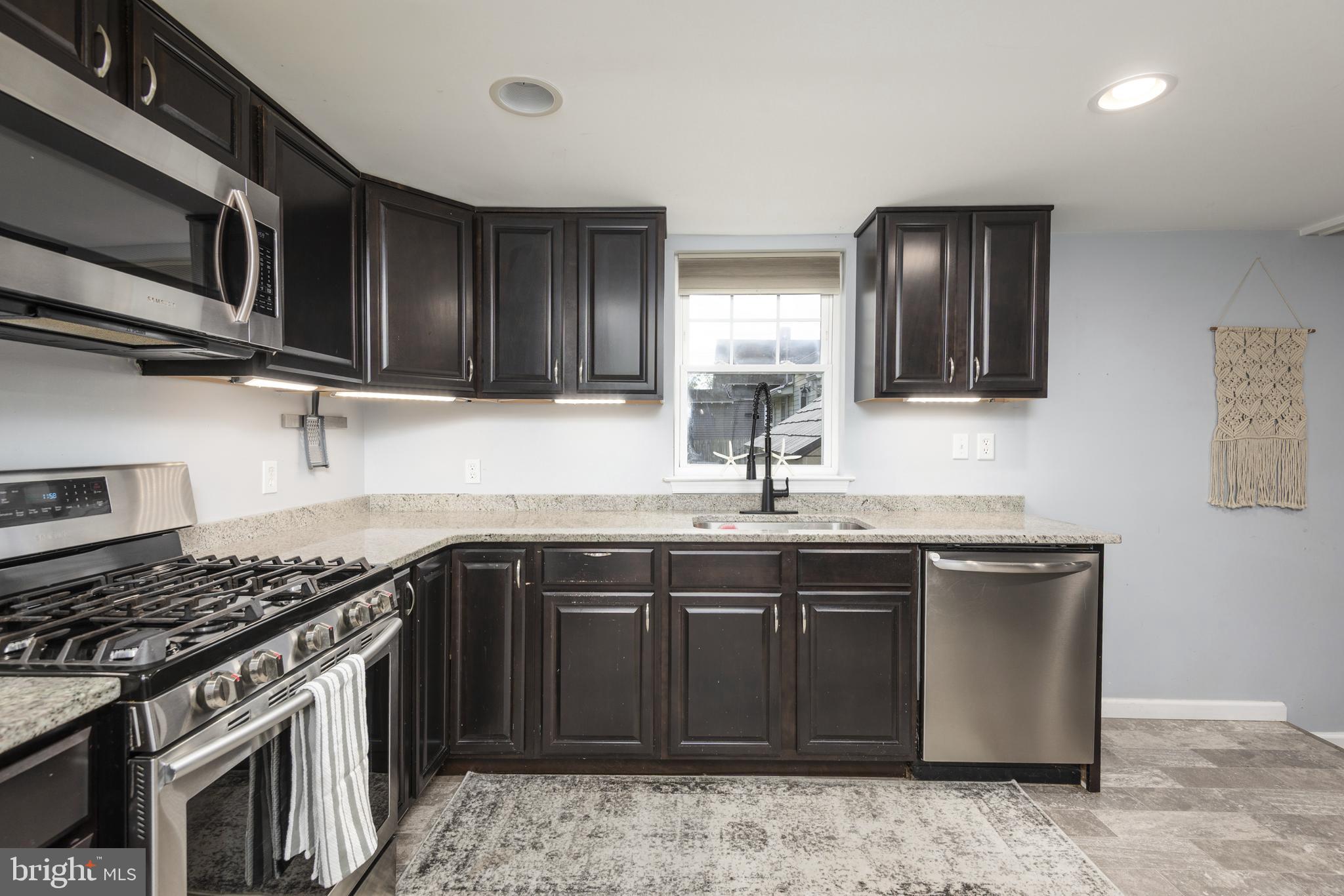 515 Franklin Street Denton, MD 21629 - Photo 7 of 21 a kitchen with stainless steel appliances granite countertop a sink stove and microwave