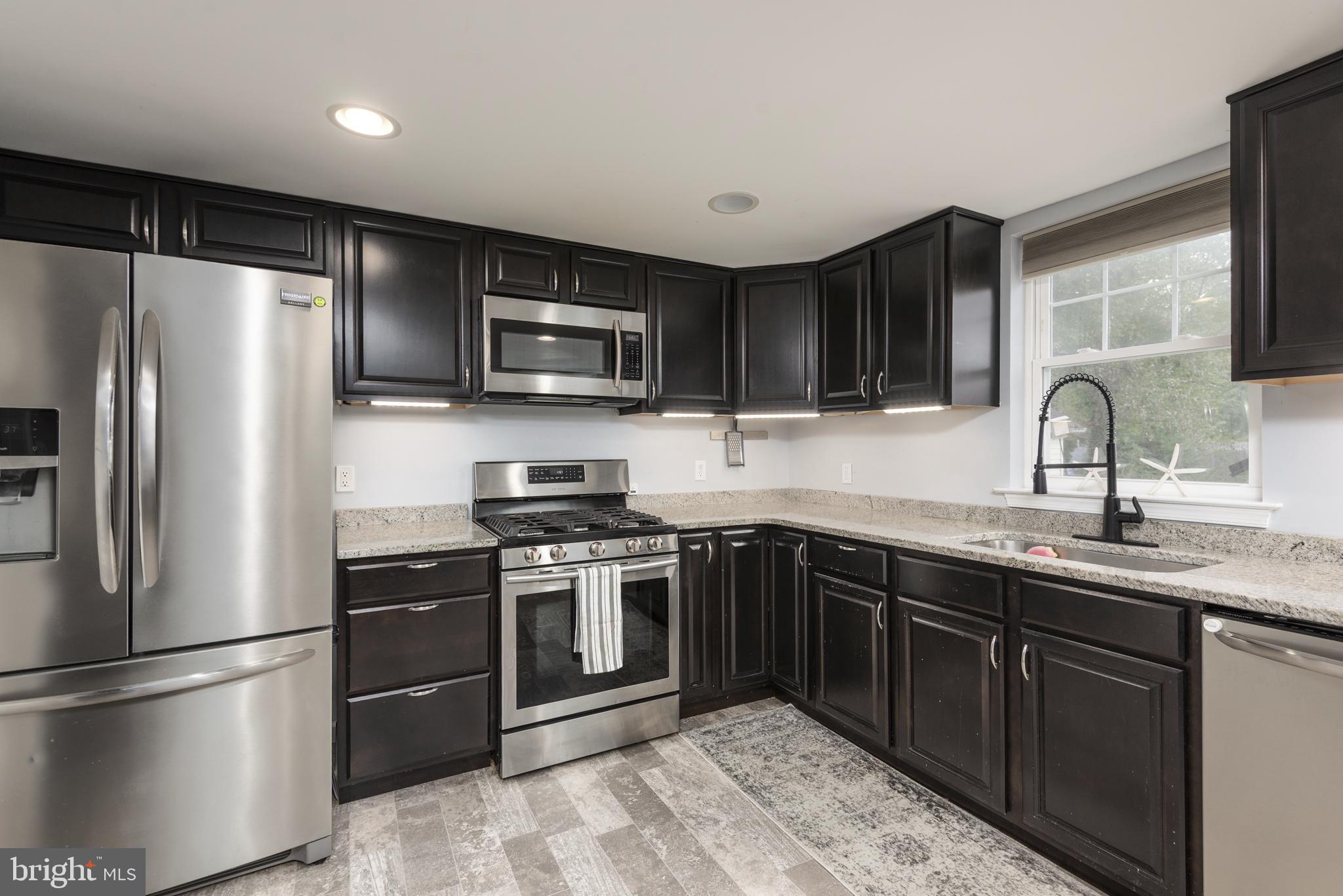 515 Franklin Street Denton, MD 21629 - Photo 8 of 21 a kitchen with stainless steel appliances granite countertop a refrigerator stove a sink and microwave