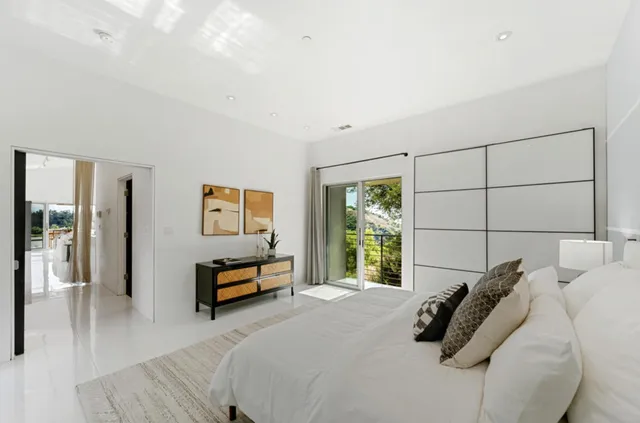 a bedroom with a bed and a large window