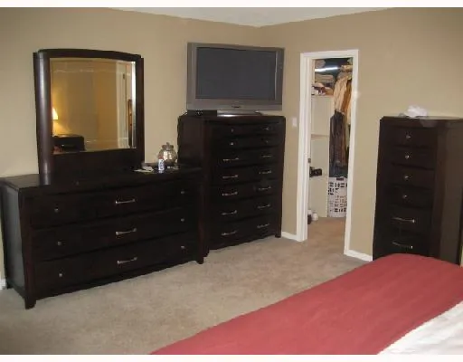 a bedroom with a dresser and a mirror