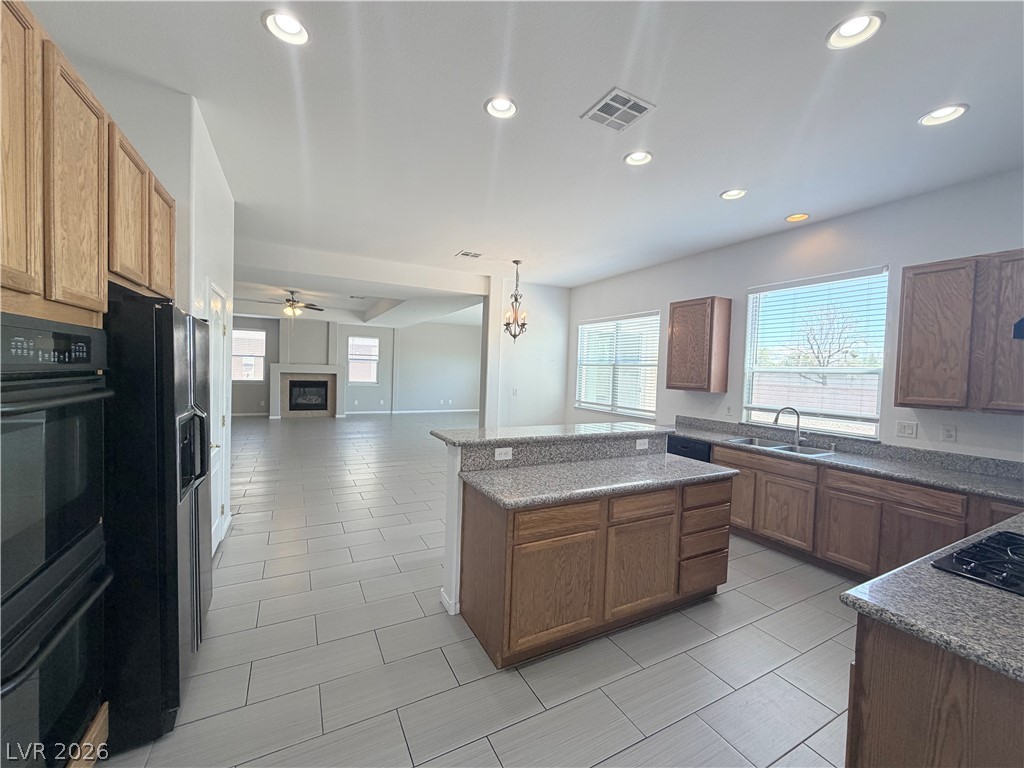 6116 Rabbit Track Street Las Vegas, NV 89130 - Photo 5 of 28 An inviting open-concept layout connects a well-appointed kitchen to a spacious living area with a cozy fireplace.