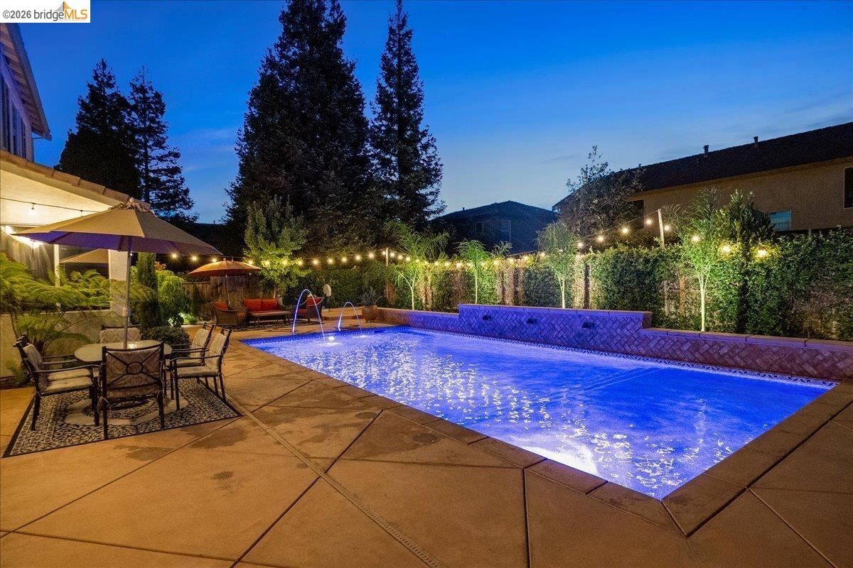 653 Bouma Lane Ripon, CA 95366 - Photo 35 of 39 Expansive backyard featuring a built-in swimming pool with fountains, concrete patio, and mature landscaping