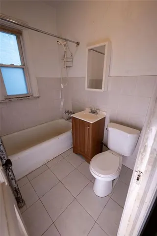 a white toilet sitting next to a bath tub