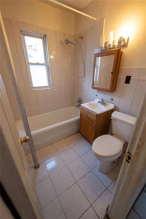 a white toilet sitting next to a bath tub