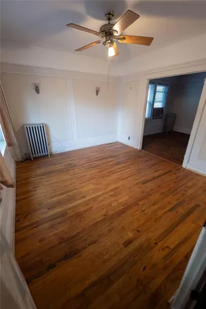 a view of empty room with window and ceiling fan