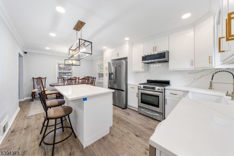 125 Meisel Avenue Springfield, NJ 07081 - Photo 10 of 32 a kitchen with a stove a sink and a refrigerator