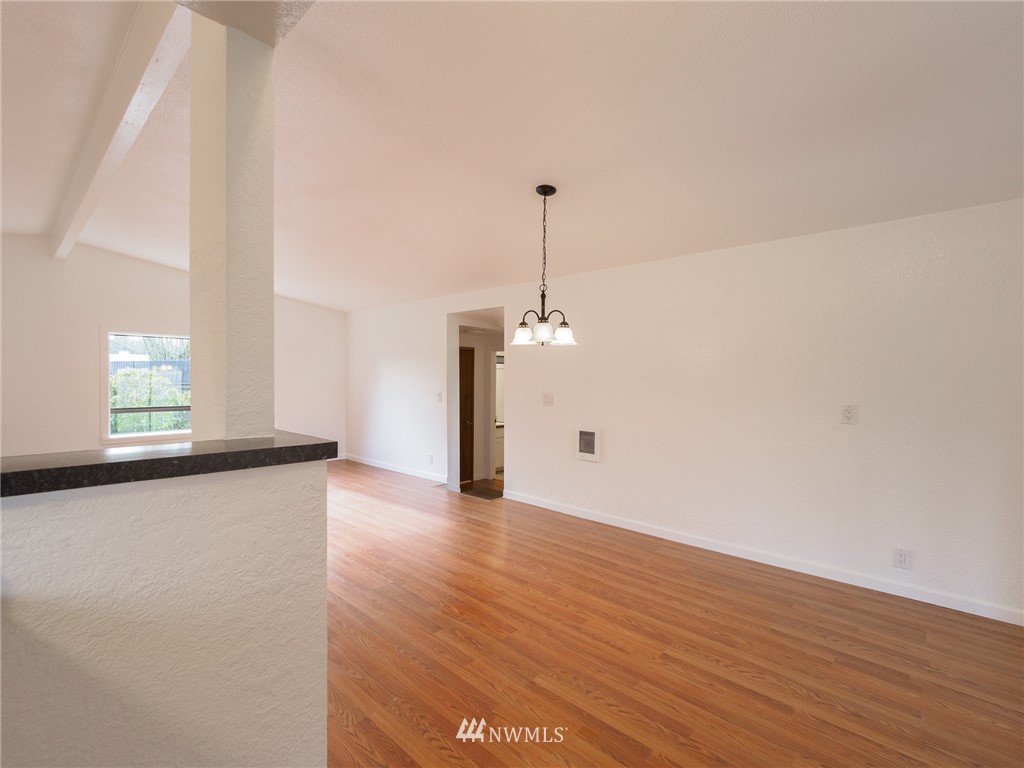 5409 Northeast 2nd Street Renton, WA 98059 - Photo 22 of 40 a view of a room with wooden floor large windows and a chandelier