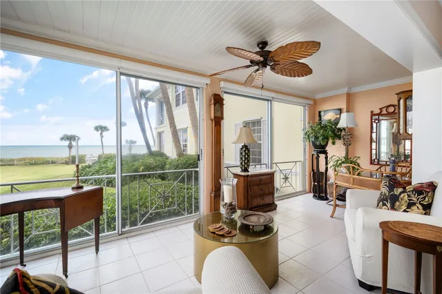 a living room with furniture floor to ceiling windows and a floor to ceiling window