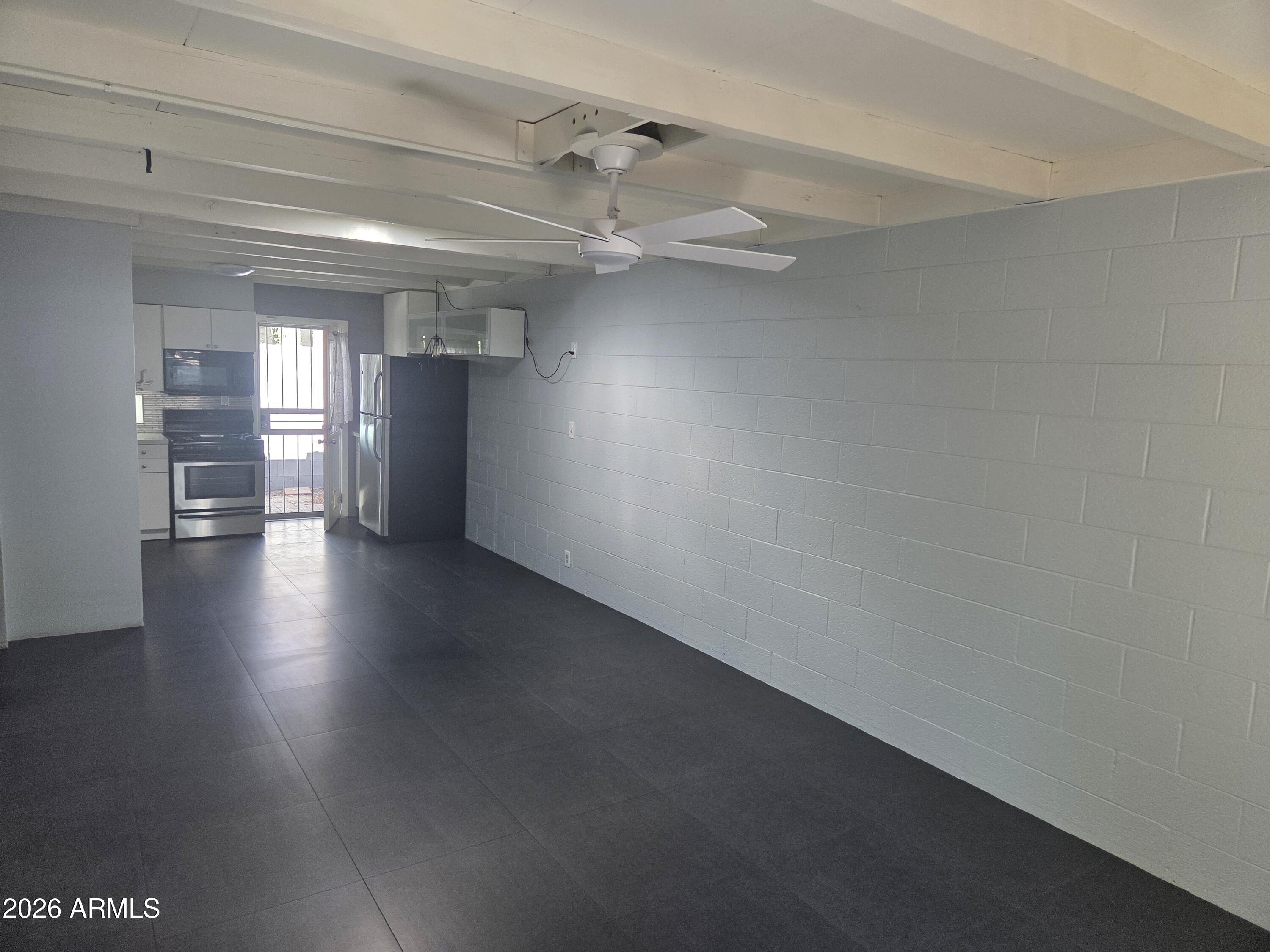 1101 East Bethany Home Road, Unit 7 Phoenix, AZ 85014 - Photo 3 of 14 an empty room with wooden floor and windows