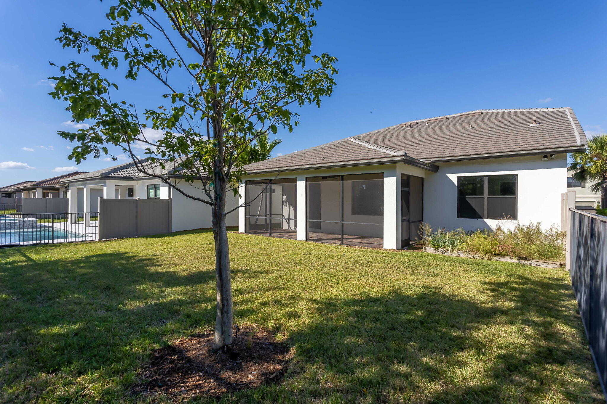 8296 Vaulting Drive Lake Worth, FL 33467 - Photo 20 of 62 a front view of a house with a garden