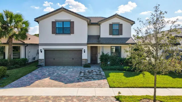 a front view of a house with a yard and garage