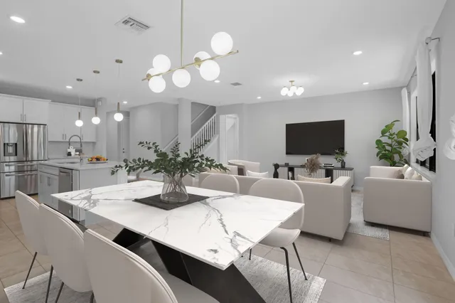 a kitchen with stainless steel appliances kitchen island granite countertop a sink a stove a dining table and chairs