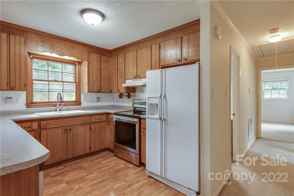 5338 Mt Gallant Road Rock Hill, SC 29732 - Photo 13 of 31 a kitchen with stainless steel appliances granite countertop a refrigerator a sink dishwasher a stove with wooden cabinets and floor
