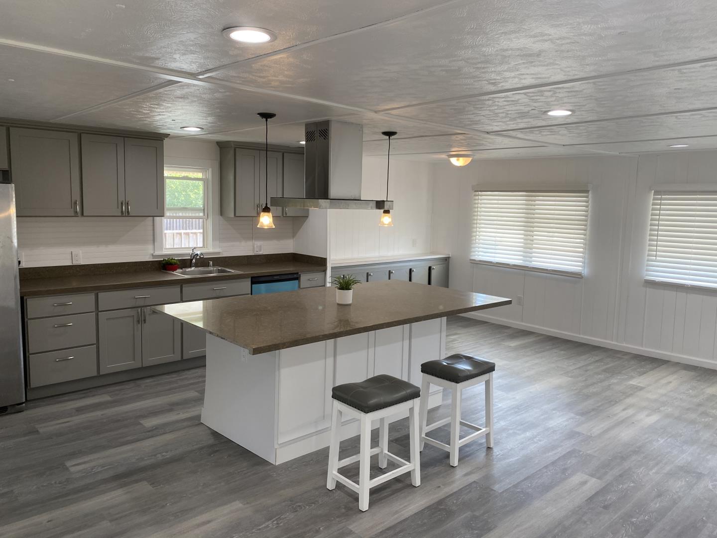 a kitchen with granite countertop a sink cabinets and wooden floor