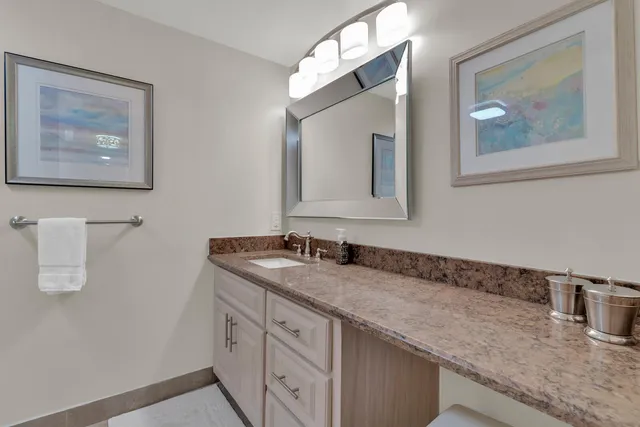 a large bedroom with a bed and flat tv screen on dresser