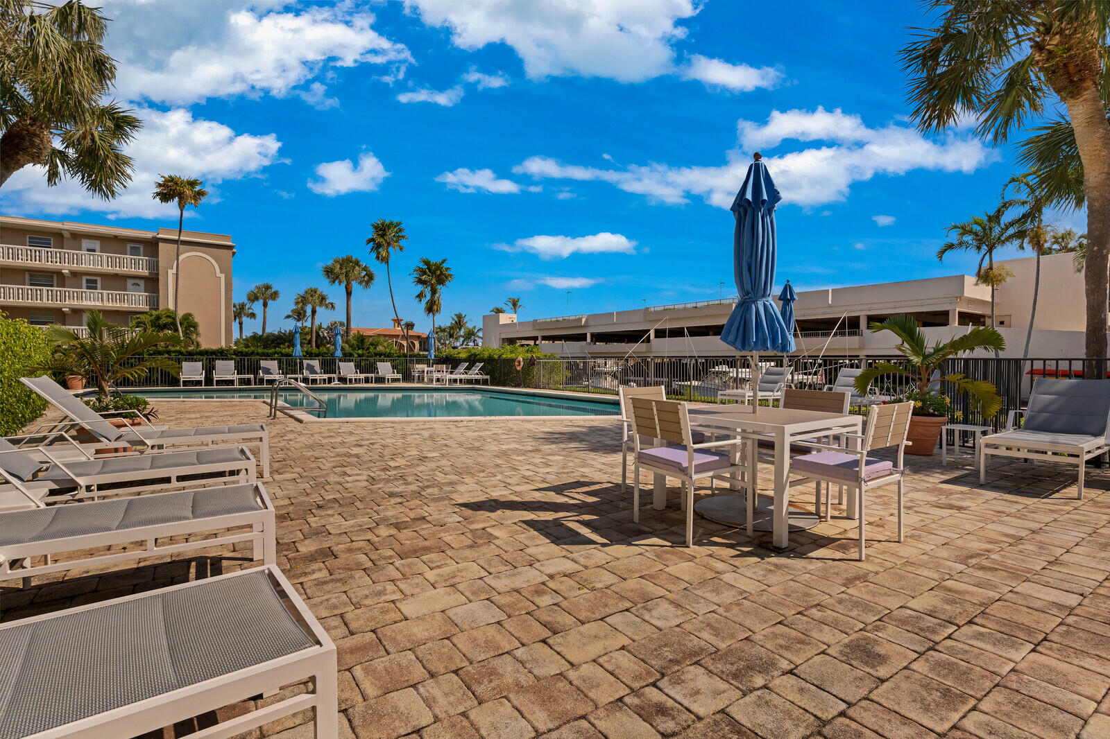 799 Jeffery Street, Unit 4070 Boca Raton, FL 33487 - Photo 32 of 41 a view of a patio with a dining table and chairs with a fire pit