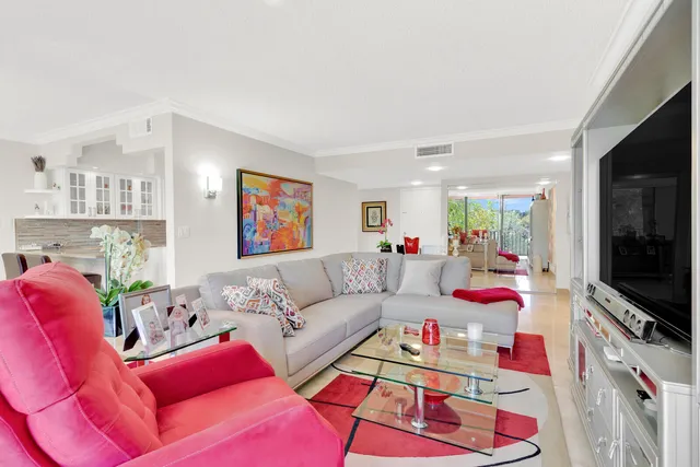 a large white kitchen with a refrigerator a sink dishwasher and a dining table with chairs