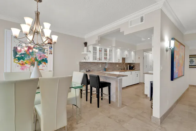 a dining room with furniture a chandelier and window