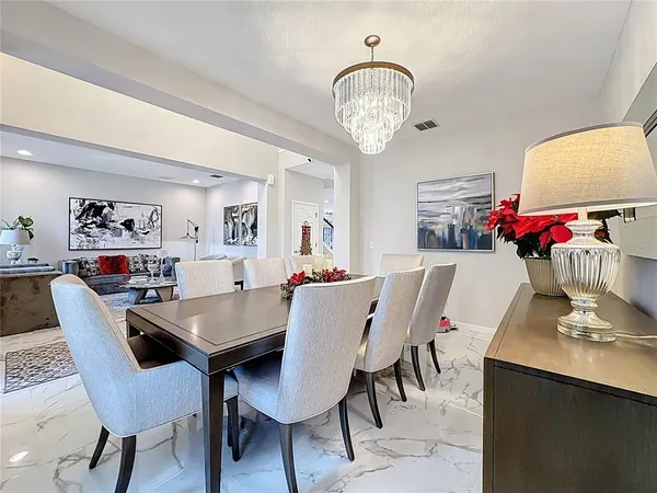 a kitchen with stainless steel appliances kitchen island granite countertop a refrigerator a stove a sink with a dining table and chairs