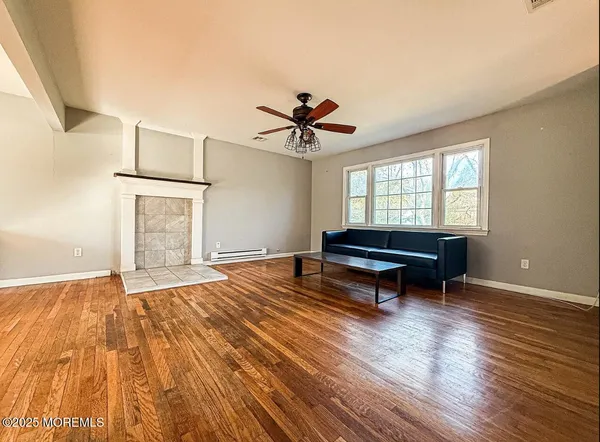 a room with wooden floor and a ceiling fan