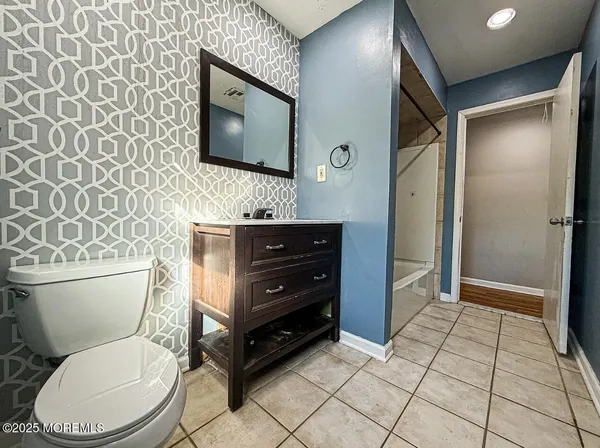 a bathroom with a toilet a sink and mirror