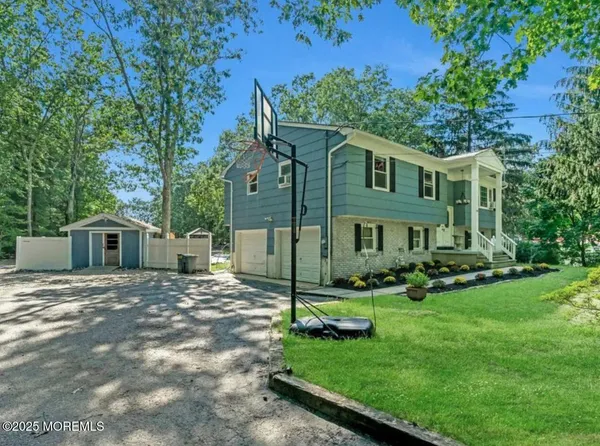 a front view of a house with a yard and trees
