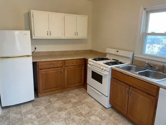 a kitchen with granite countertop white cabinets and white appliances