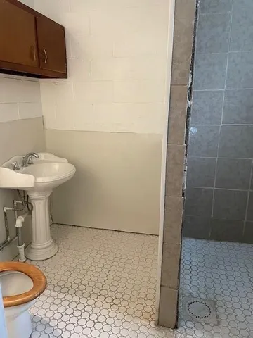 a bathroom with a sink a toilet and a mirror