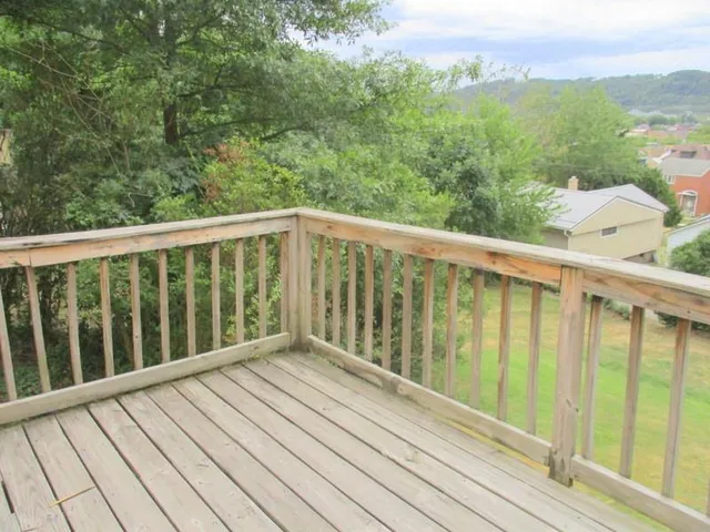 a view of balcony with wooden floor and fence