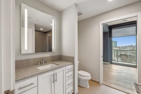 a bathroom with a granite countertop sink toilet and shower