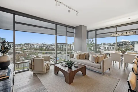 a living room with furniture and a floor to ceiling window
