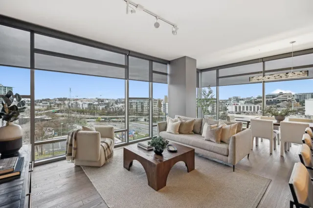 a living room with furniture and a floor to ceiling window