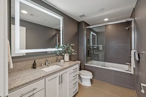 a bathroom with a granite countertop sink toilet and shower