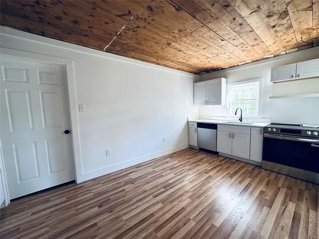 a view of a kitchen with wooden floor and sink