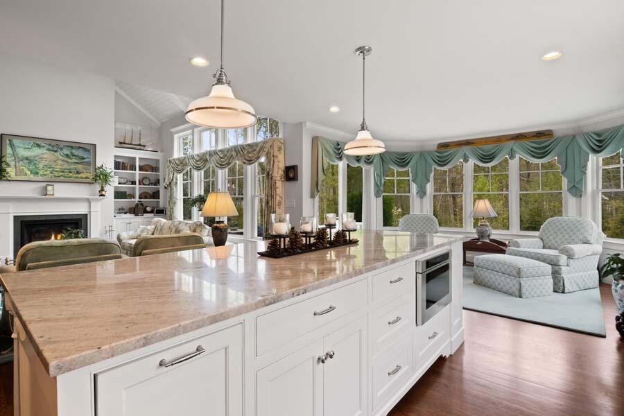 19 Bascom Hollow Harwich, MA 02645 - Photo 12 of 43 an open kitchen with granite countertop a stove and white cabinets with wooden floor